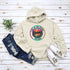 Featuring a stunning lake scene with a vibrant sunset, this hoodie captures the beauty of Lake of the Woods in Ontario, where tranquil waters meet the warm glow of a setting sun.